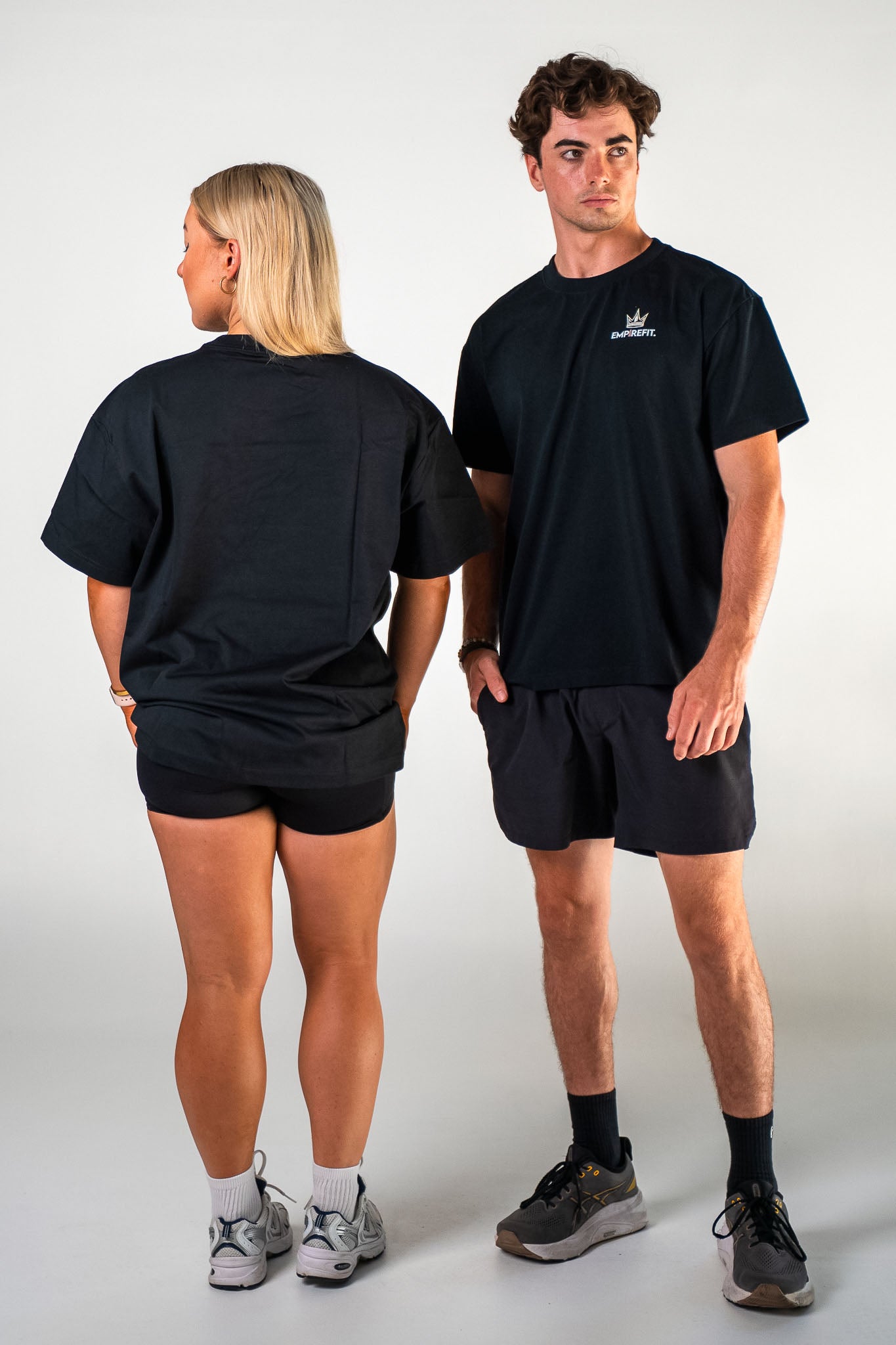 Athletes wearing the black Essentials Crown Tee relaxed fit gym t-shirt by Empire Fit showing front and back