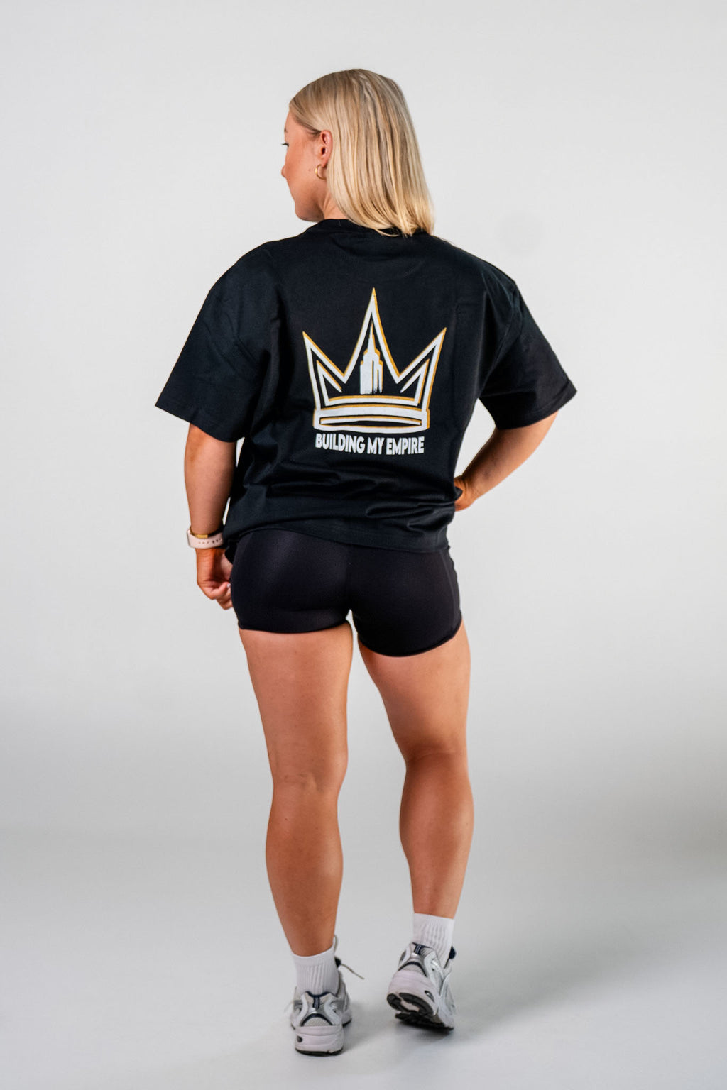 Back view of female athlete wearing the black Builders Tee relaxed fit gym t-shirt Building My Empire graphic by Empire Fit