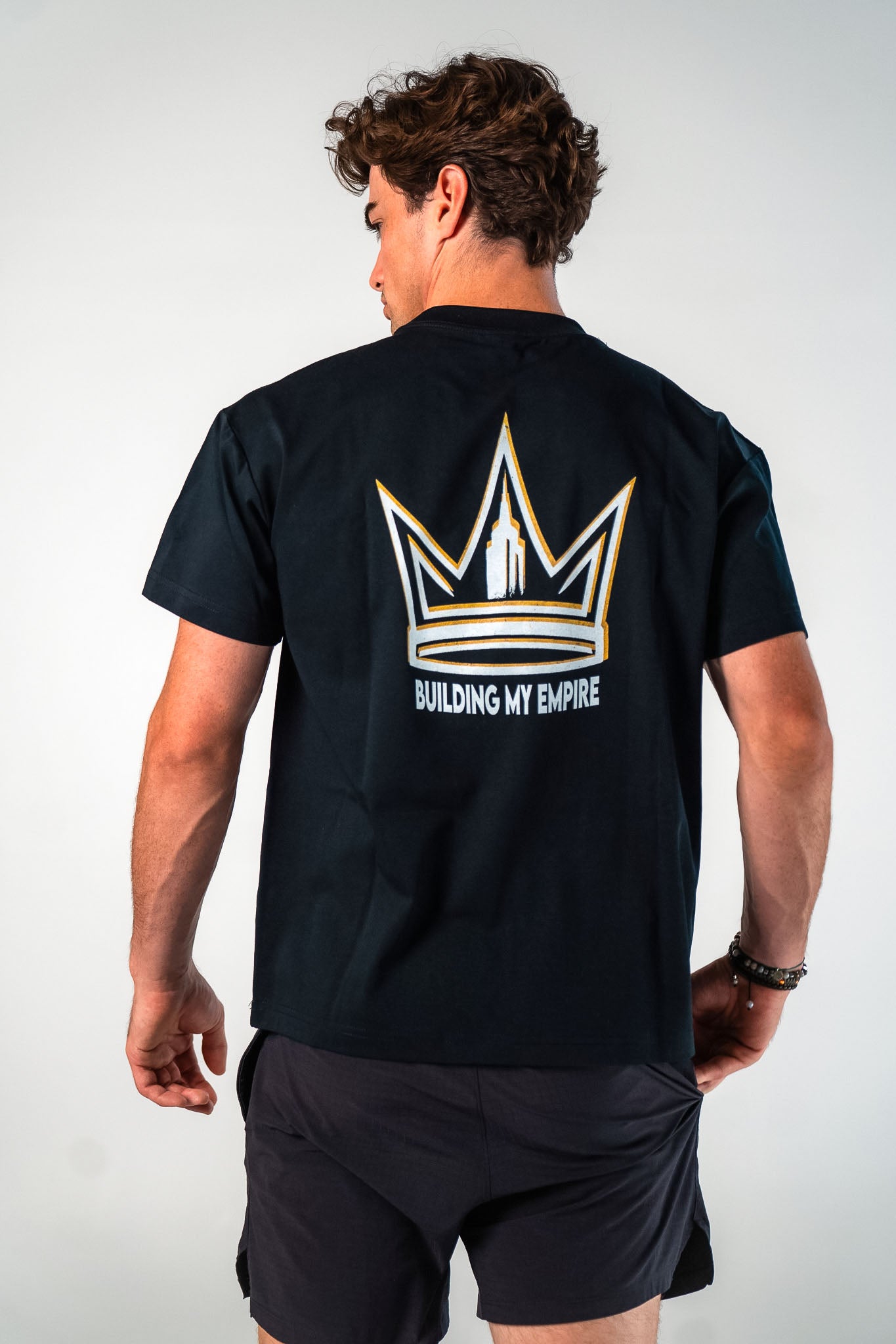 Back view of male athlete wearing the black Builders Tee relaxed fit gym t-shirt Building My Empire graphic by Empire Fit