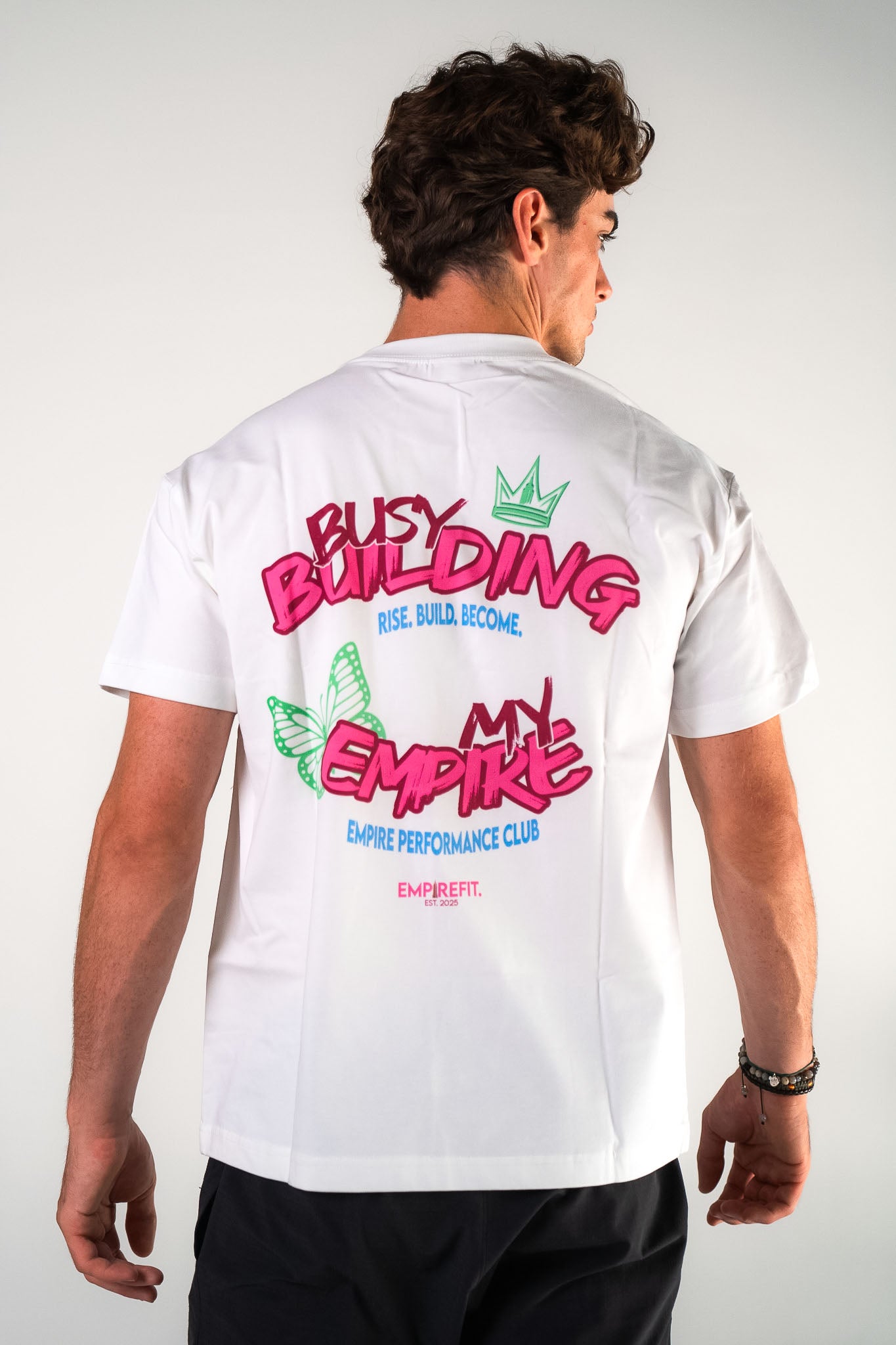 Back view of male athlete wearing the white Busy Building My Empire tee graphic gym t-shirt motivational fitness apparel by Empire Fit