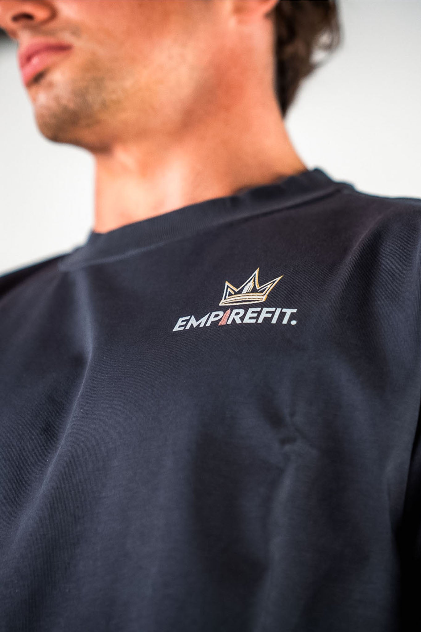 Close-up of the Empire Fit crown logo on the charcoal Builders Tee relaxed fit gym t-shirt chest detail