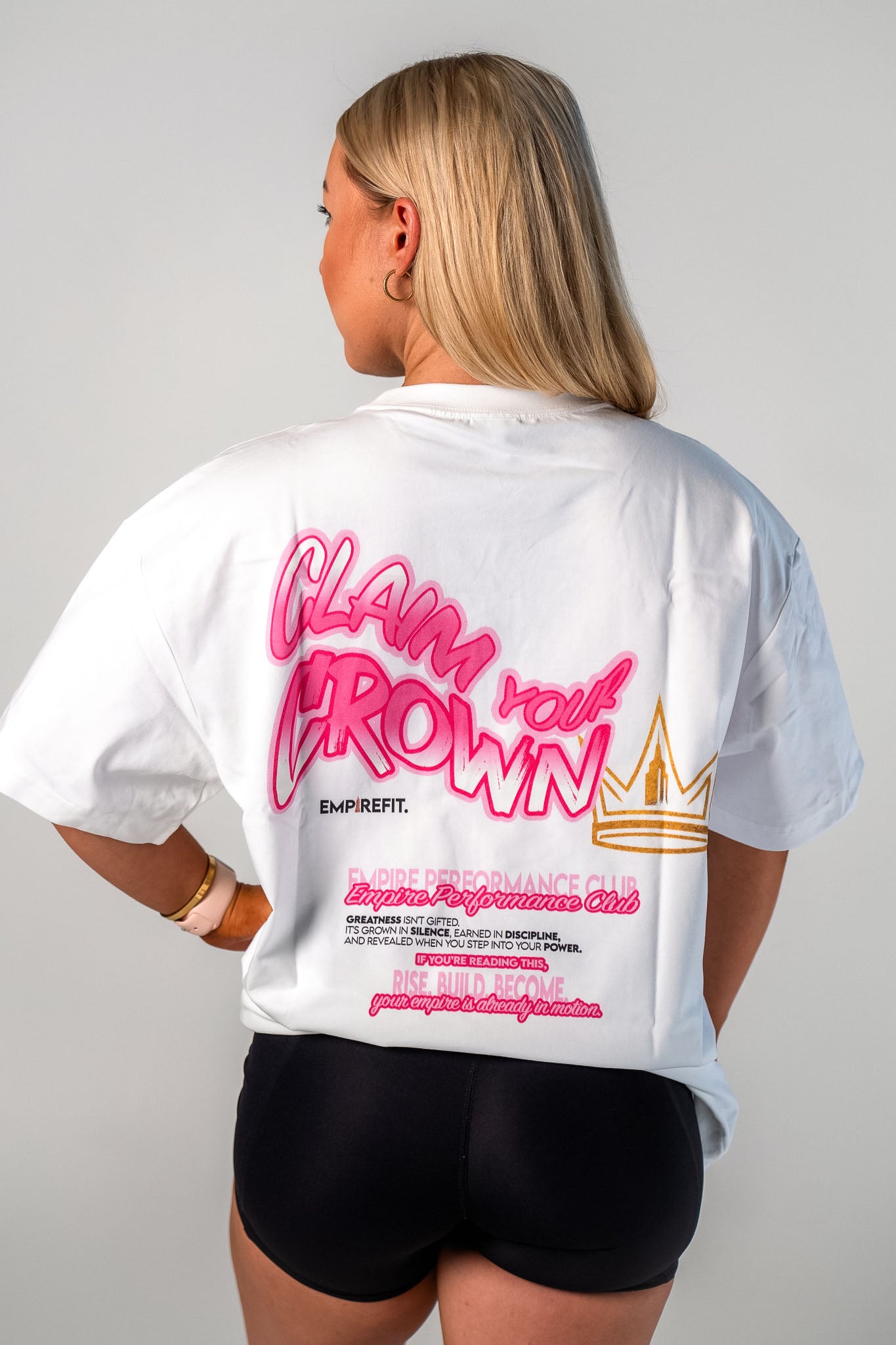 Female athlete wearing the pink Claim Your Crown Tee with crown graphic by Empire Fit