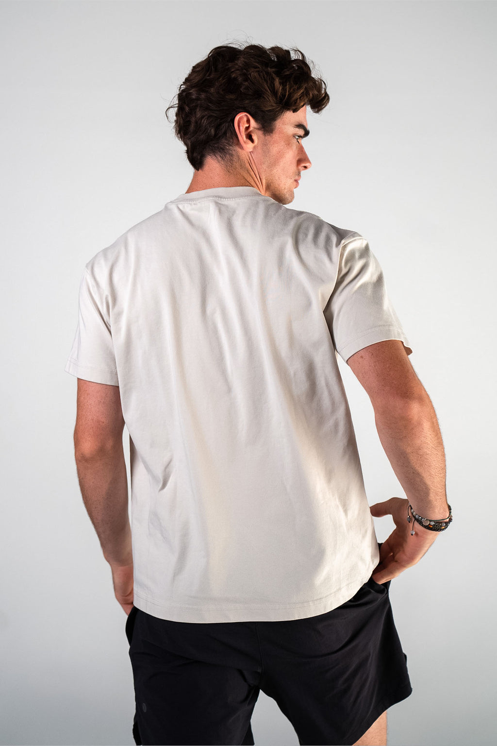 Male athlete wearing the beige Essentials Crown Tee relaxed fit gym t-shirt by Empire Fit