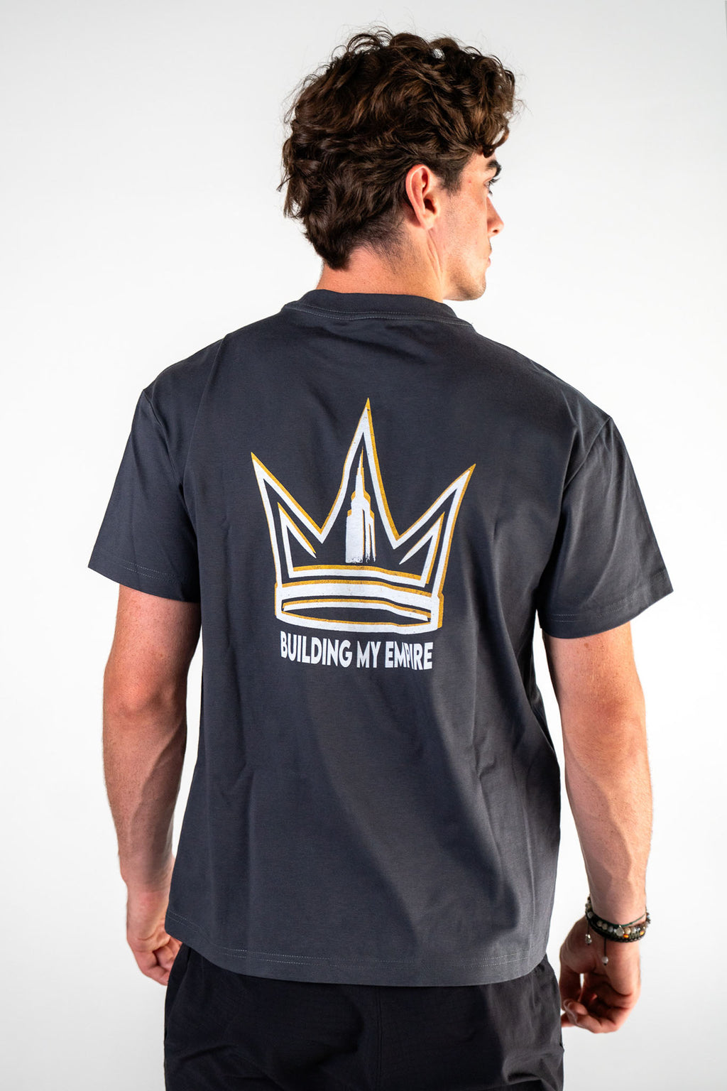 Male athlete wearing the charcoal Builders Tee relaxed fit gym t-shirt by Empire Fit back view
