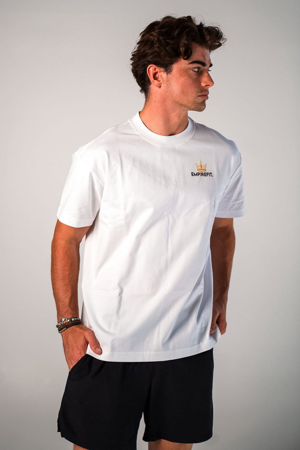 Male model wearing the white and black Claim Your Crown Tee relaxed fit gym t-shirt by Empire Fit